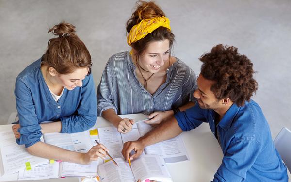 3 students looking at books